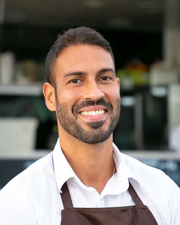A smiling café owner in an apron