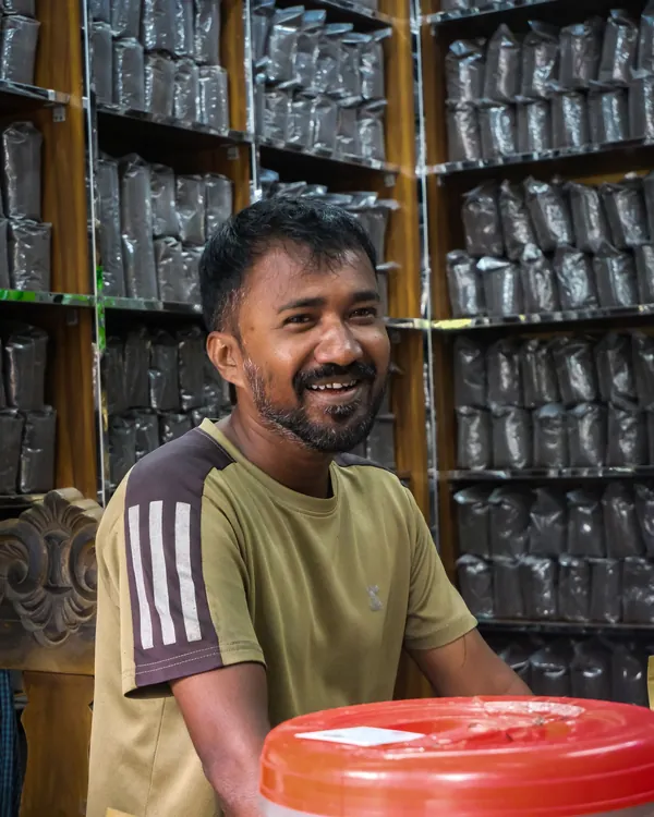 A smiling shopkeeper in his tea shop